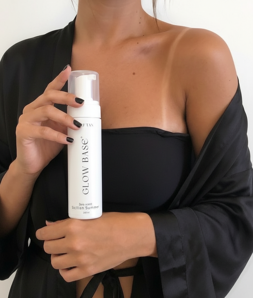 Model bottle of 'Glow Base' product against a neutral background